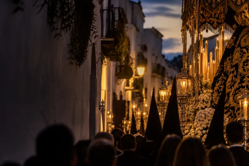 Ambientación conceptual de una procesión al anochecer, sin representar un municipio concreto